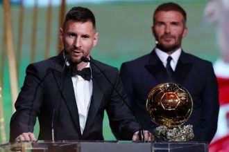 Inter Miami co-owner David Beckham stands behind Argentine football legedn Lionel Messi as he gives a speech after receiving his Ballon dOr award on October 30, 2023. — Reuters