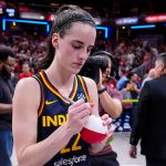 Caitlin Clark signs a ball